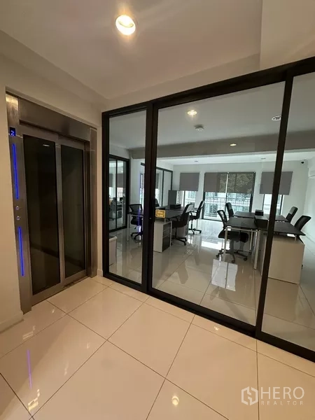Home Office for rent - Lift lobby with blue-lit private elevator beside glass-partitioned offices.