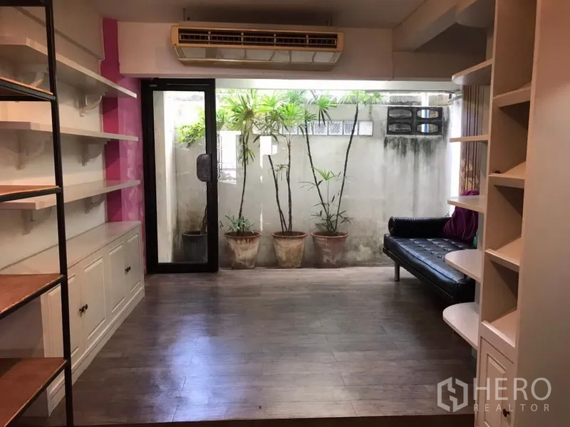 零售空间 出租在Khlong Toei, Bangkok - 后室设有柜体与层架，大型空调，玻璃滑门外为盆景小庭院。