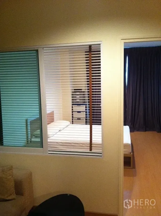 คอนโด ให้เช่าในWatthana, Bangkok - มุมมองผ่านบานกระจกพร้อมมู่ลี่เข้าสู่ห้องนอน มีเตียง ตู้ลิ้นชัก และผ้าม่านทึบ