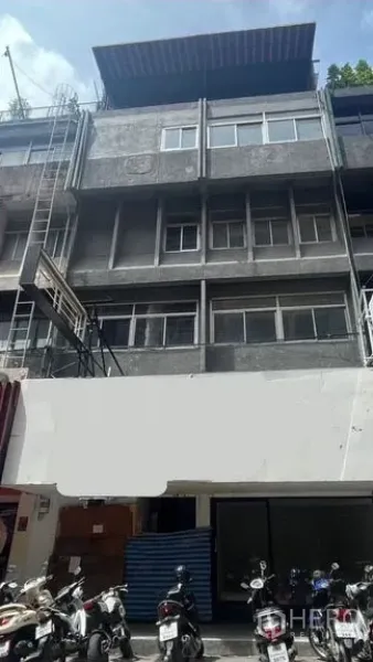 店屋 出租在Bang Rak, Bangkok - 四层混凝土店屋外立面，Silom区街边玻璃门面，门前停放摩托车