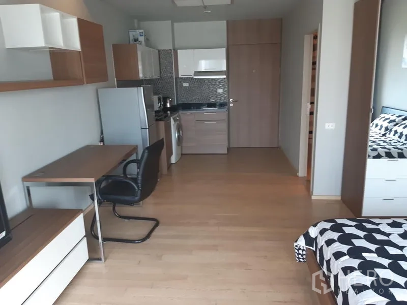 คอนโด ให้เช่าในBangkok - พื้นที่เปิดโล่งมีโต๊ะทำงาน ตู้ทีวี ชั้นลอย และครัวขนาดกะทัดรัดพร้อมตู้เย็นและเครื่องซักผ้า