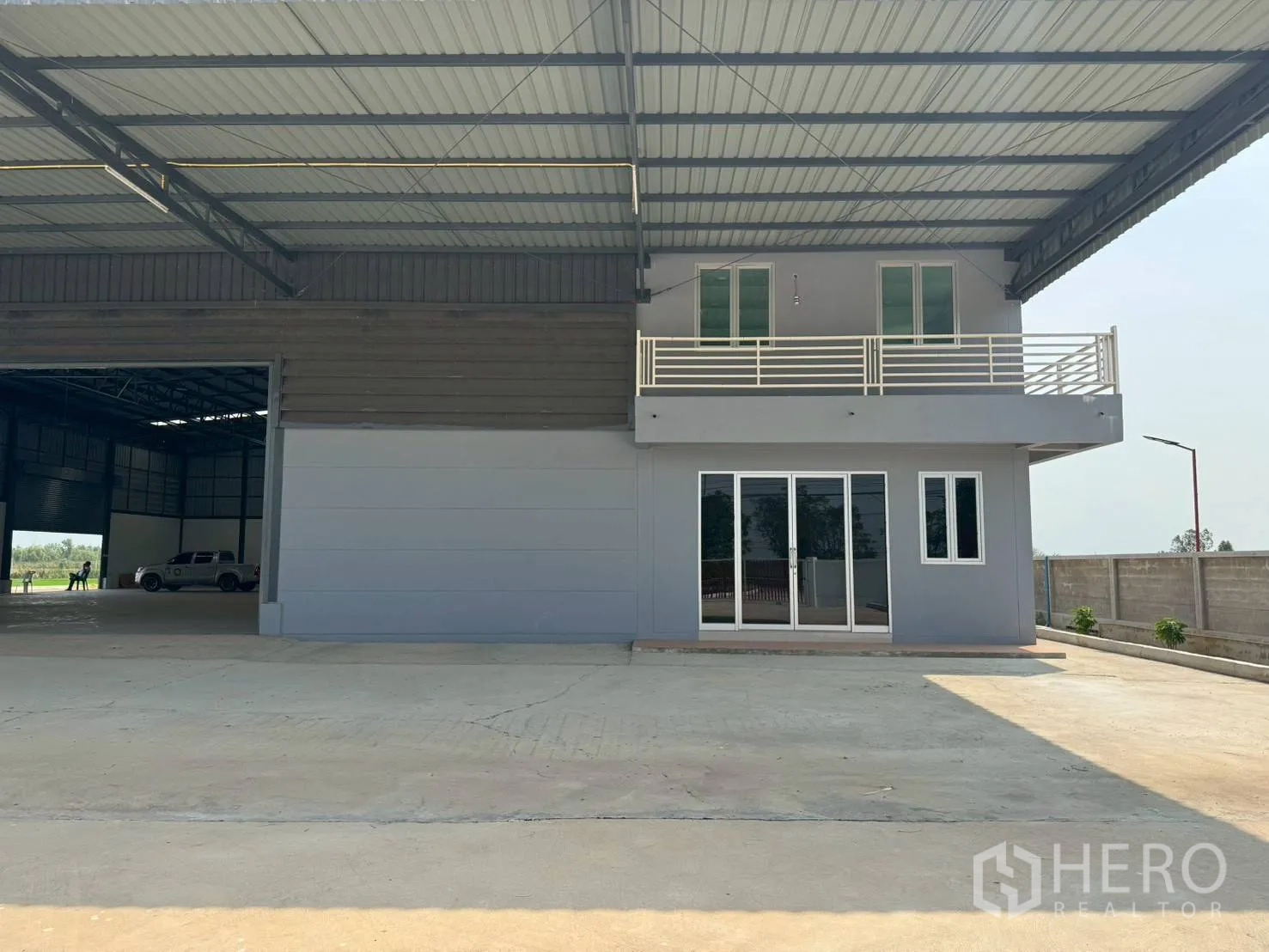 Warehouse for rent in Phutthamonthon, Nakhon Pathom - Two-storey office block under the warehouse loading canopy with balcony and glass doors.