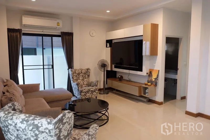Detached House for rent in Bang Phli, Samut Prakan - TV feature wall in the living room with access to a guest bathroom.