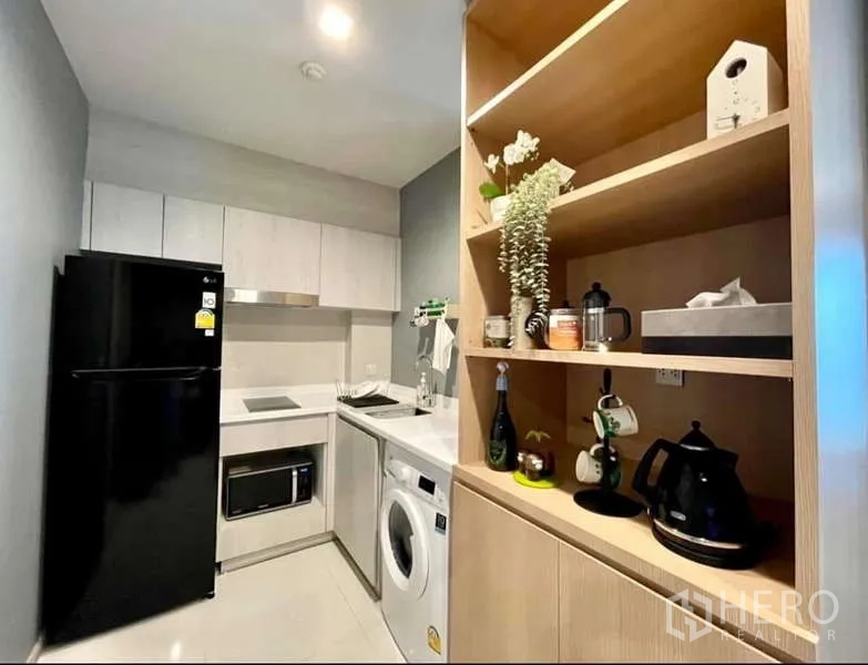 Condominium for rent in Pathum Wan, Bangkok - Fitted kitchen with black refrigerator, open shelving and washer under the counter