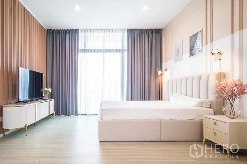 ทาวน์เฮาส์ ให้เช่าหรือขายในSuan Luang, Bangkok - ห้องนอนใหญ่สว่าง เตียงคิงส์ไซส์ ผ้าม่านสูงจรดเพดาน และตู้วางทีวีเรียบหรู