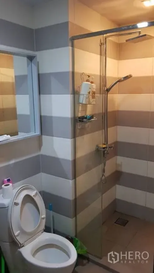 คอนโด ขายในWatthana, Bangkok - ห้องน้ำปูกระเบื้องลายแถบ พร้อมฉากกั้นกระจกและฝักบัวเรนชาวเวอร์ รวมถึงโถสุขภัณฑ์