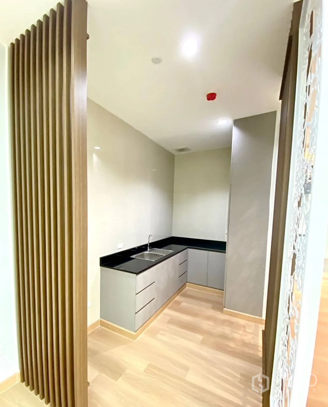 Office Space for rent - Pantry nook behind vertical slats with L-shaped counter and sink.