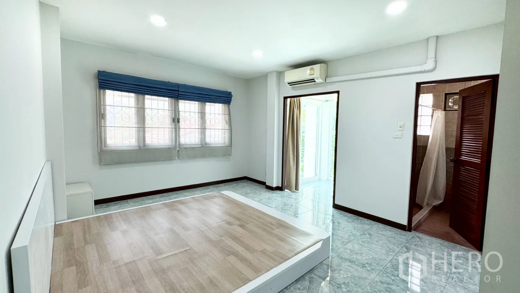 独栋房屋 for rent in Suan Luang, Bangkok - 卧室带平台式床架，蓝色窗帘帘盒，直通套内浴室。