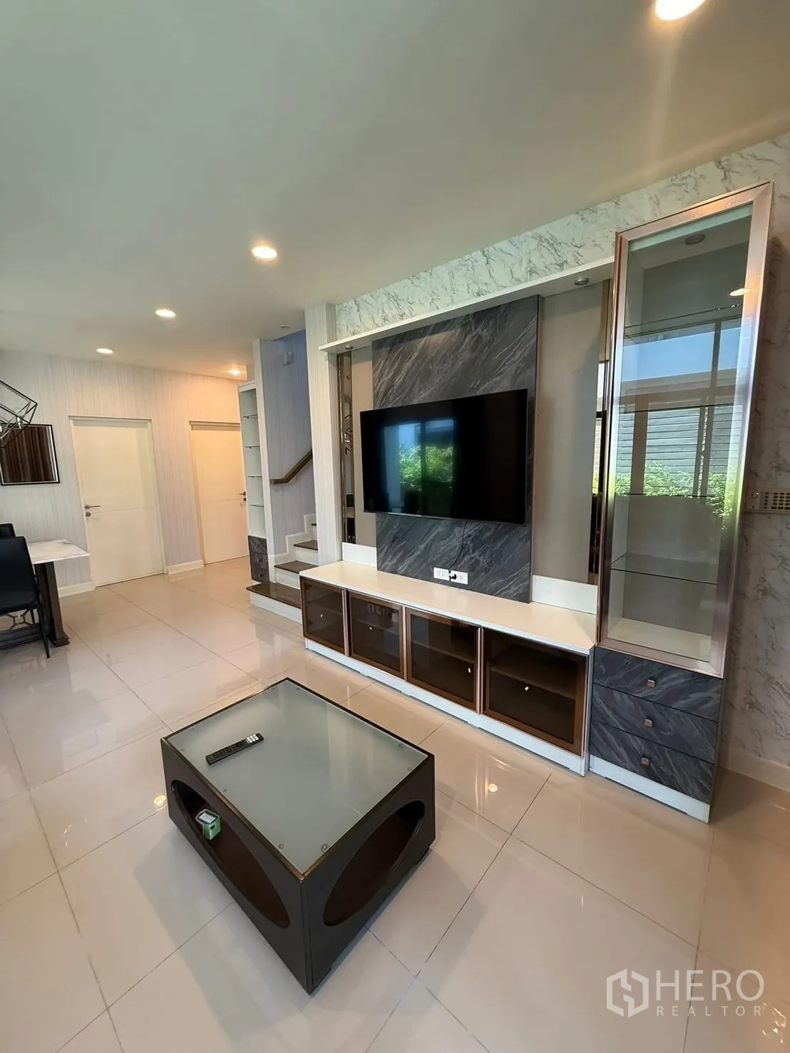 Detached House for rent in Prawet, Bangkok - Living room media wall with mounted TV, marble accents and storage cabinets.