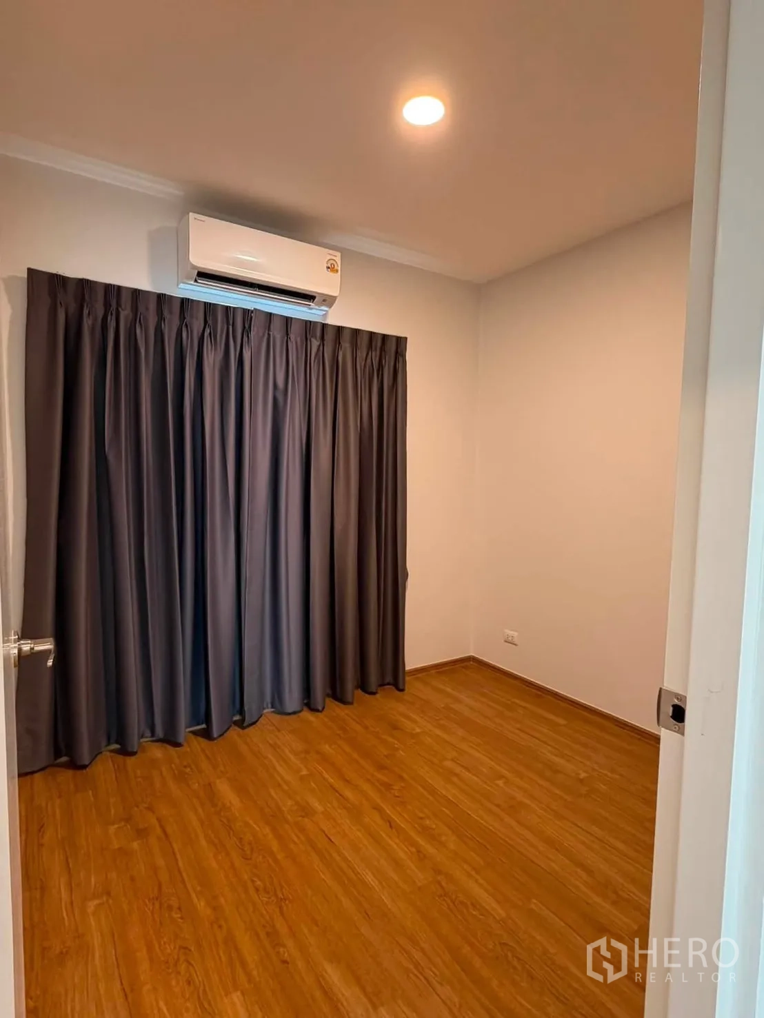 Townhouse for rent in Bang Phli, Samut Prakan - Air-conditioned room with wood flooring and blackout curtains.