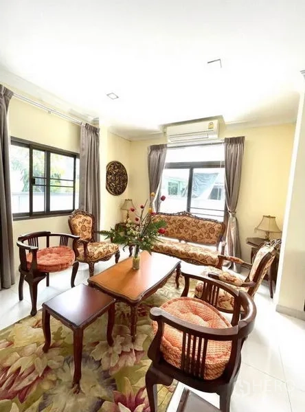 独立式住宅 出租在Prawet, Bangkok - 采光充足的客厅，经典木质沙发组合与大窗帘。