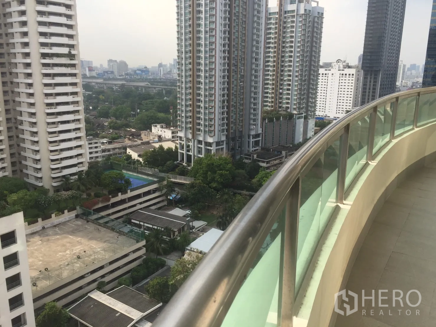 คอนโด for ในWatthana, Bangkok - ระเบียงโค้งราวกระจก มองเห็นวิวเส้นขอบฟ้าและตึกสูงใจกลางกรุงเทพฯ