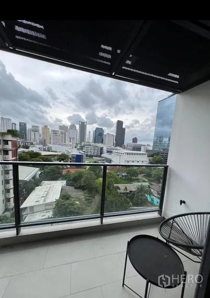 Condominium for rent in Watthana, Bangkok - Private balcony with glass railing, bistro set and skyline view.