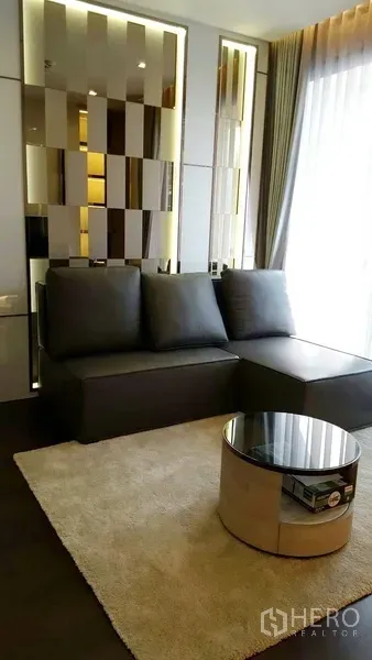 คอนโด ให้เช่าในWatthana, Bangkok - โซนพักผ่อนกะทัดรัด โซฟาเข้ามุมสีเข้ม ผนังกระจกเงา และโต๊ะกลางทรงกลม