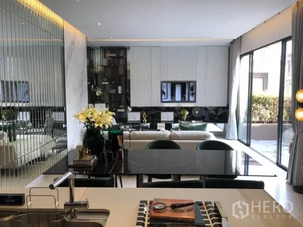 独立式住宅 出售在Bang Kapi, Bangkok - 开放式客厅与餐区，镜面墙、黑色餐桌，落地移门通向露台。