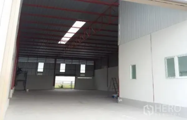 工厂 出租在Pathum Thani - 高挑厂房，红色钢桁架与天窗，并设侧墙办公室窗口。