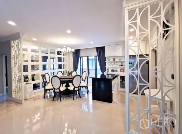 Detached House for rent or sale in Bang Kapi, Bangkok - Open-plan dining and kitchen with island, mirrored feature wall, decorative partitions, and glossy floors.