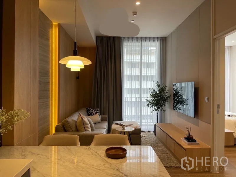 คอนโด ให้เช่าหรือขายในPathum Wan, Bangkok - มุมมองจากครัวไปยังห้องนั่งเล่น โคมไฟแขวน หน้าต่างสูงจรดเพดาน และทางเข้าห้องนอน