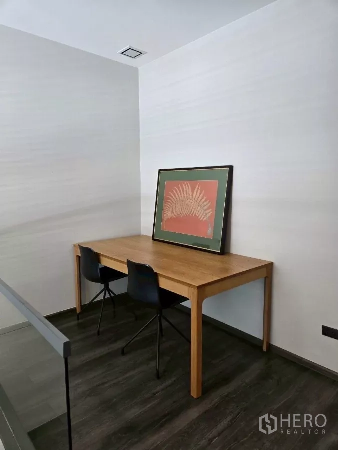 Townhouse for rent in Bang Phli, Samut Prakan - Upstairs study nook with wooden desk and two chairs on dark wood flooring.