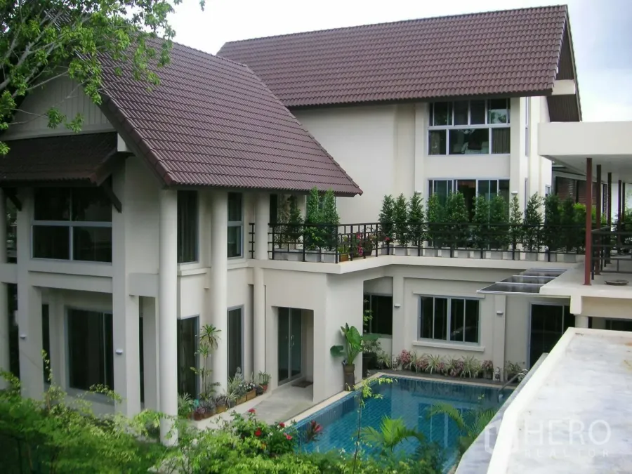 Detached House for rent or sale in Prawet, Bangkok - Two-storey detached house in Prawet, Bangkok with tiled roof, balconies and a central private pool surrounded by greenery.
