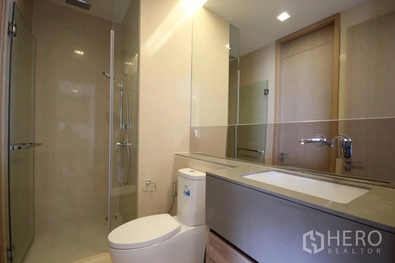 Condominium for rent in Watthana, Bangkok - Sleek bathroom with glass-enclosed rain shower, wide vanity, and modern fixtures.