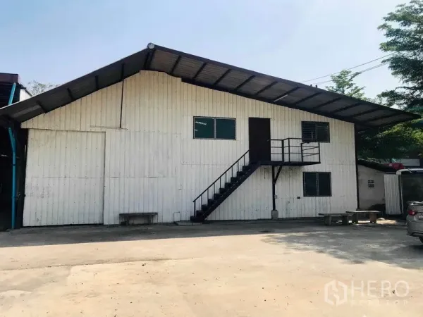 คลังสินค้า ให้เช่าในPathum Thani - ด้านหน้าอาคารโกดัง มีบันไดขึ้นชั้นบนและลานคอนกรีตกว้าง