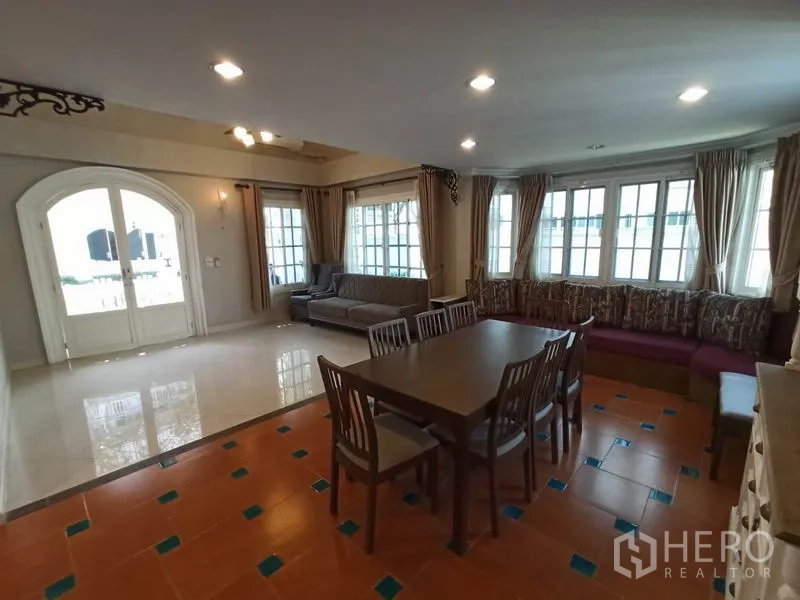 独立式住宅 出租在Mueang Samut Prakan, Samut Prakan - 明亮的起居餐厅，拱形双开门与窗帘，采光充足。