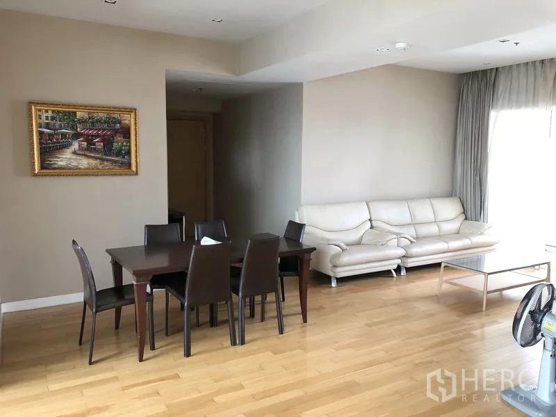 คอนโด ให้เช่าในKhlong Toei, Bangkok - มุมทานอาหารพร้อมโต๊ะหกที่นั่งและโซฟาหนังสีครีมในห้องนั่งเล่น