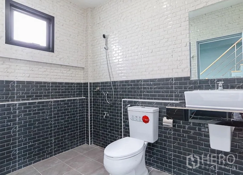 Shophouse for sale in Lam Luk Ka, Pathum Thani - Tiled bathroom with window, shower, basin and toilet in the commercial unit.