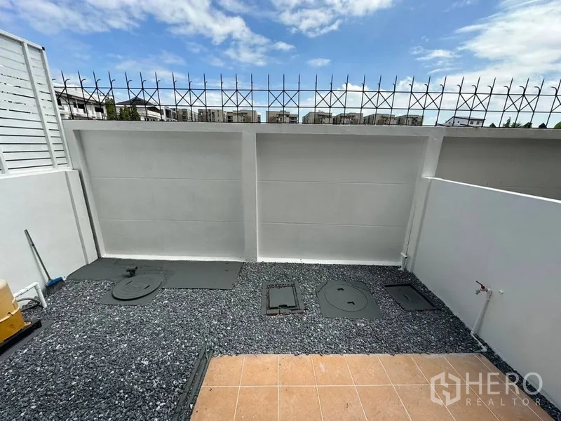 ทาวน์เฮาส์ ให้เช่าหรือขายในPhra Khanong, Bangkok - ลานซักล้างด้านหลัง ปูหินเกล็ด พร้อมกำแพงสูงและท้องฟ้าโปร่ง