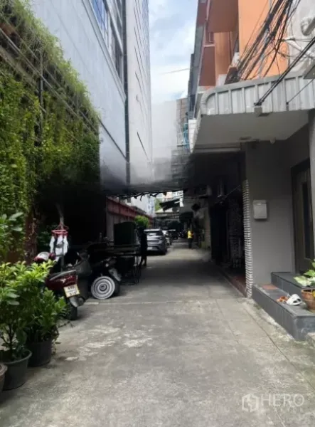 店屋 出售 - 建筑旁安静小巷，绿植与低层邻里，临时停车位。