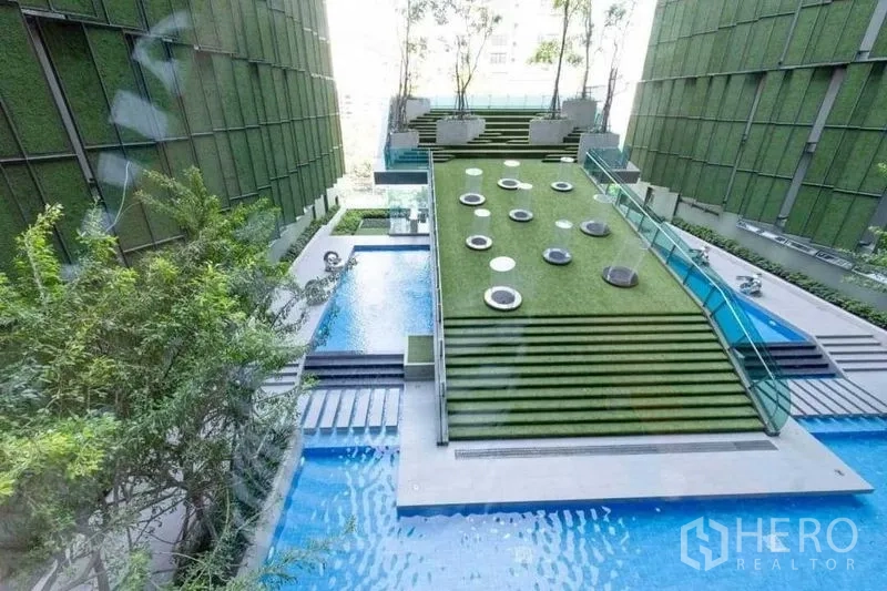 Condominium for sale in Ratchathewi, Bangkok - Tiered lawn sky garden with seating pods above reflective water features at the condo.