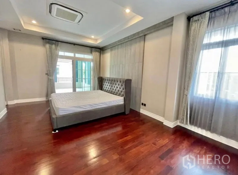 Detached House for rent in Bang Phli, Samut Prakan - Spacious master bedroom with tray ceiling, wood floors and balcony doors.