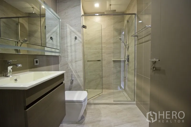 คอนโด ให้เช่าในWatthana, Bangkok - ห้องน้ำทันสมัยพร้อมอ่างล้างหน้า โถสุขภัณฑ์ และห้องอาบน้ำแบบกั้นกระจกฝักบัวเรนชาวเวอร์ โทนหินอ่อนอ่อน