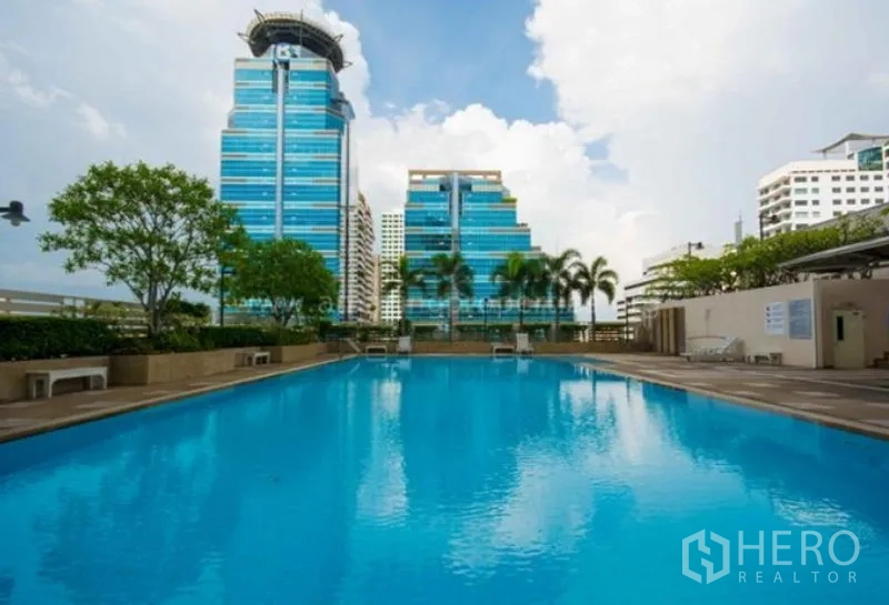 公寓 出租在Watthana, Bangkok - 户外大型游泳池，背靠城市天际线。