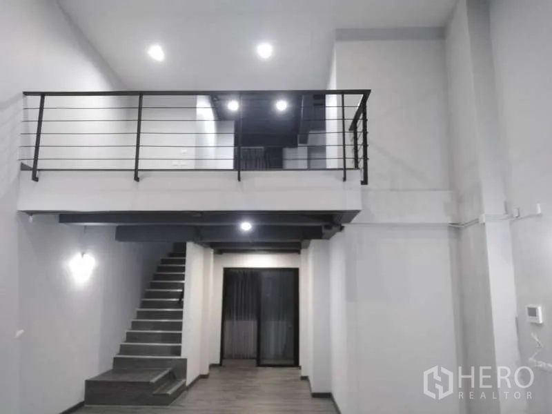 Home Office for rent or sale - Double-height living and working space featuring a mezzanine level and metal balustrade under spotlights.