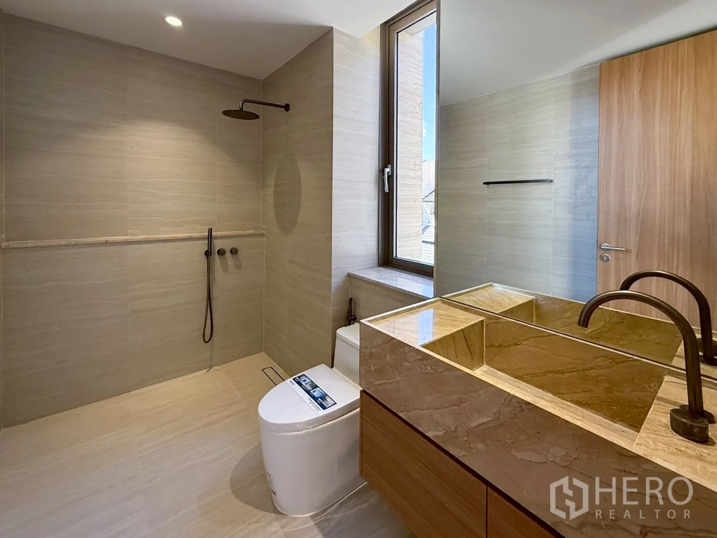 家庭办公室 for rent or sale in Watthana, Bangkok - 米色瓷砖浴室，带窗与加长大理石台盆。