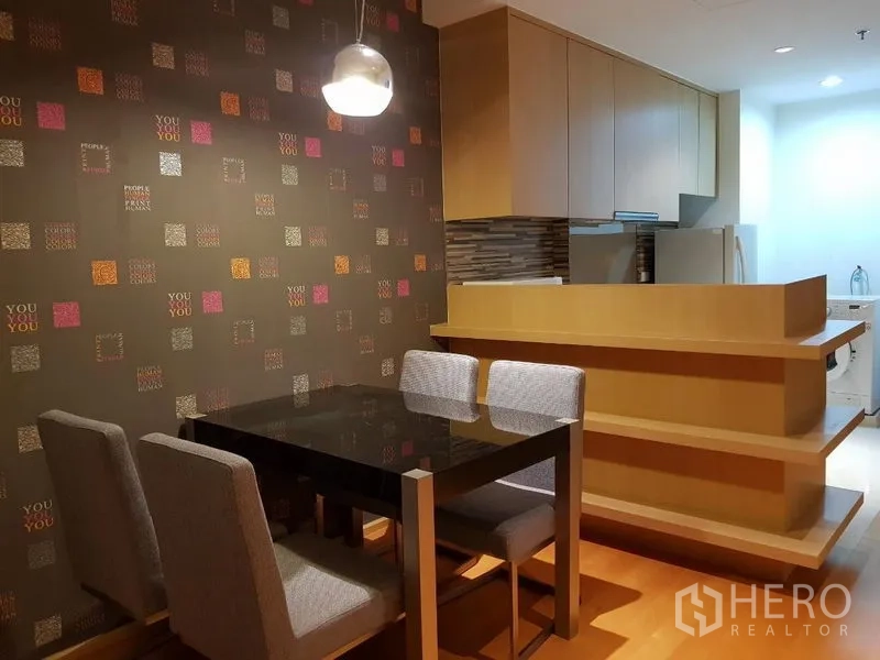 คอนโด ให้เช่าในRatchathewi, Bangkok - มุมทานอาหารผนังลายกราฟิก ข้างเคาน์เตอร์ครัวไม้สีอ่อน มองเห็นโซนซักผ้า