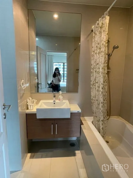 คอนโด ให้เช่าในBangkok - ห้องน้ำสะอาด กระจกบานใหญ่ ผ้าม่าน และอ่างอาบน้ำพร้อมฝักบัว