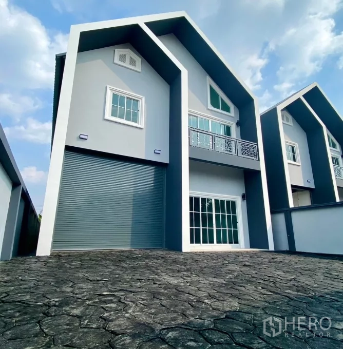 工厂 出租或出售在Bang Bua Thong, Nonthaburi - 正立面配大卷闸门、阳台与宽幅推拉玻璃门。