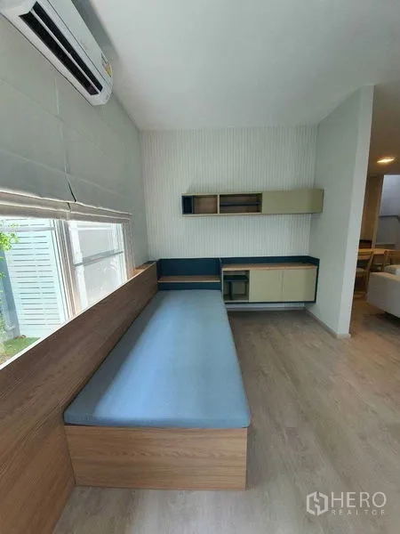 Townhouse for rent - Cozy family room with a long built-in bench, storage cabinets, and an air conditioner.