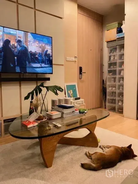 公寓 出租或出售在Chatuchak, Bangkok - Muji风客厅，壁挂电视、玻璃茶几与内置收纳柜。