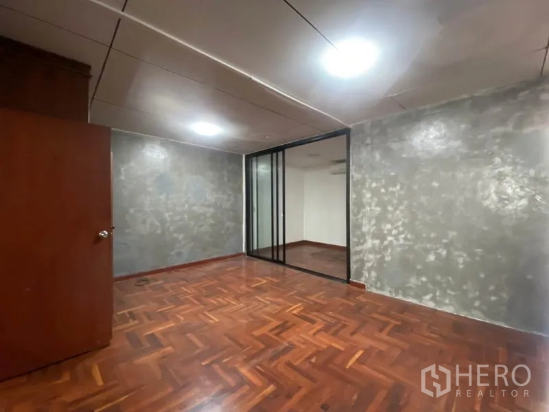 ทาวน์เฮาส์ ให้เช่าในWatthana, Bangkok - ห้องมีฉากกั้นกระจกบานเลื่อนและพื้นปาร์เกต์ เหมาะทำออฟฟิศหรือห้องเสริม.