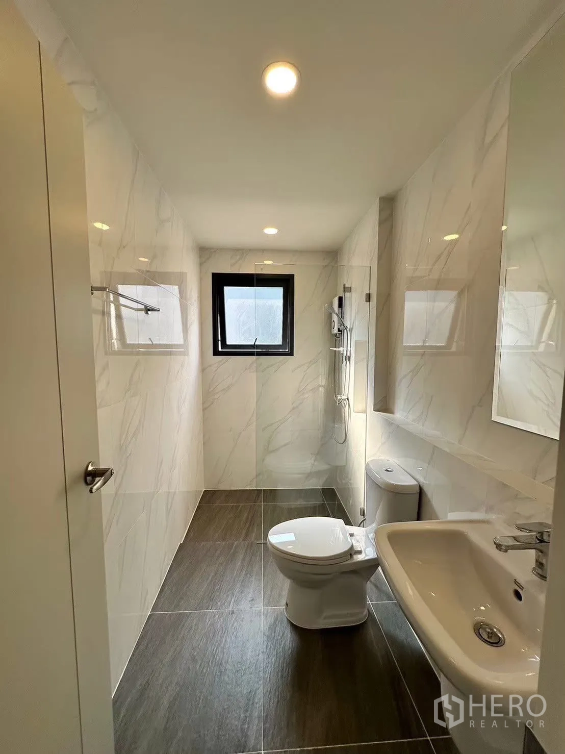 Detached House for rent in Bang Phli, Samut Prakan - Bathroom with marble-look tiles, walk-in shower, toilet and basin.