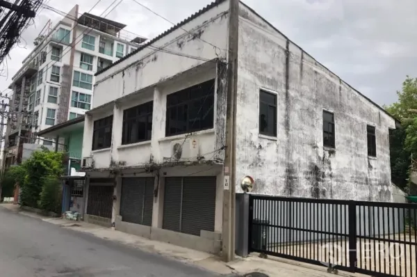 ที่ดิน ขายในPhra Khanong, Bangkok - อาคารคอนกรีตสูงสองชั้นและที่ดินมีรั้วรอบบนซอยเงียบย่านพระโขนง มีคอนโดมิเนียมด้านหลัง.