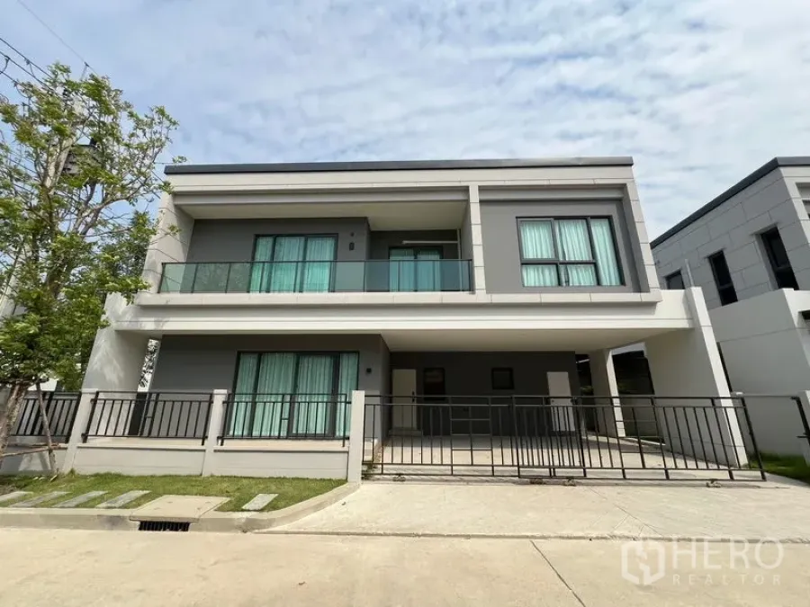 Detached House for rent in Bang Phli, Samut Prakan - Modern two-storey detached house facade with balcony, gated carport and lawn in Bang Phli.