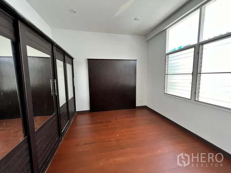 带办公室的家 出租在Watthana, Bangkok - 卧室带深色木质嵌入式衣柜与大窗。