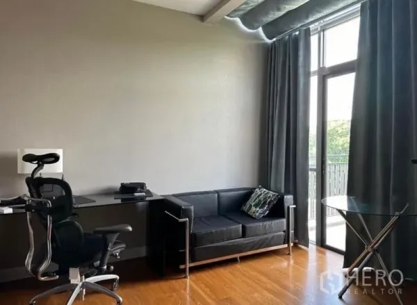 独立式住宅 出租 - 明亮的书房，人体工学椅、黑色沙发，落地玻璃门通向阳台.