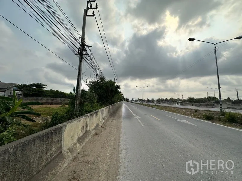 Land for sale in Bang Bua Thong, Nonthaburi - Straight section of Road 345 with streetlights and overhead lines under a cloudy sky near the plot.