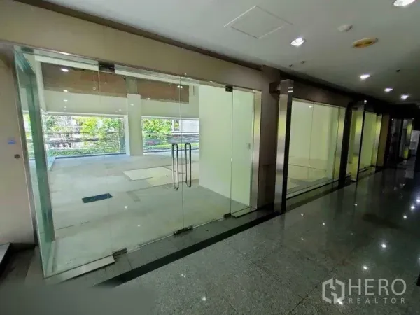 零售空间 出租在Khlong Toei, Bangkok - 室内走廊旁的双扇玻璃门入口。